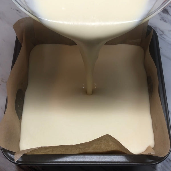 pouring butter mochi batter into the prepared baking pan