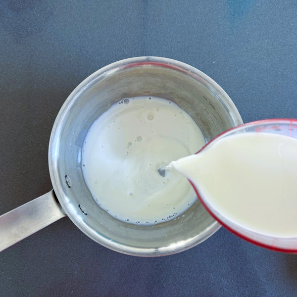 adding milk to a small pot