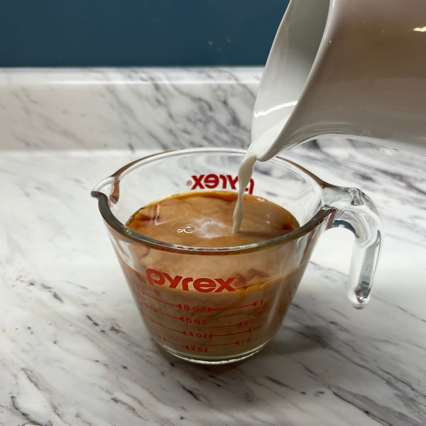 pouring milk into the black tea