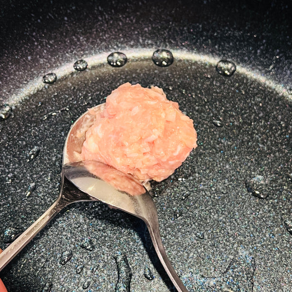 putting the tsukune in a frying pan