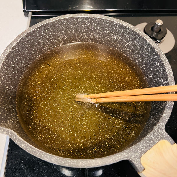 checking the temperature of the oil with chopsticks