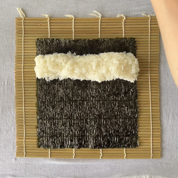 spreading the sushi rice onto the nori seaweed