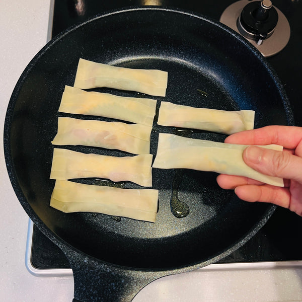 placing the chicken gyoza into the oiled frying pan