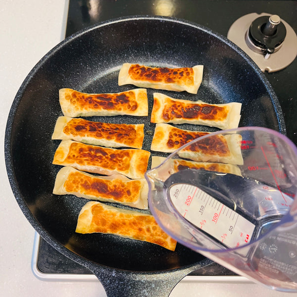 flipping the gyoza onto the other side once golden brown