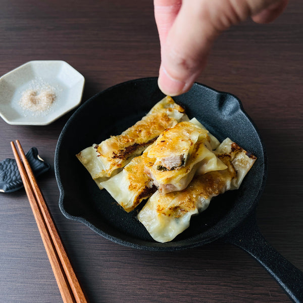 sprinkling the chicken gyoza with salt