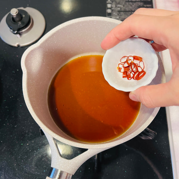 adding sliced chili pepper to the nanban sauce