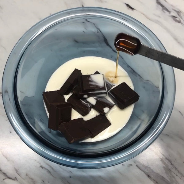 adding heavy cream, chocolate, and rum into a microwave safe bowl