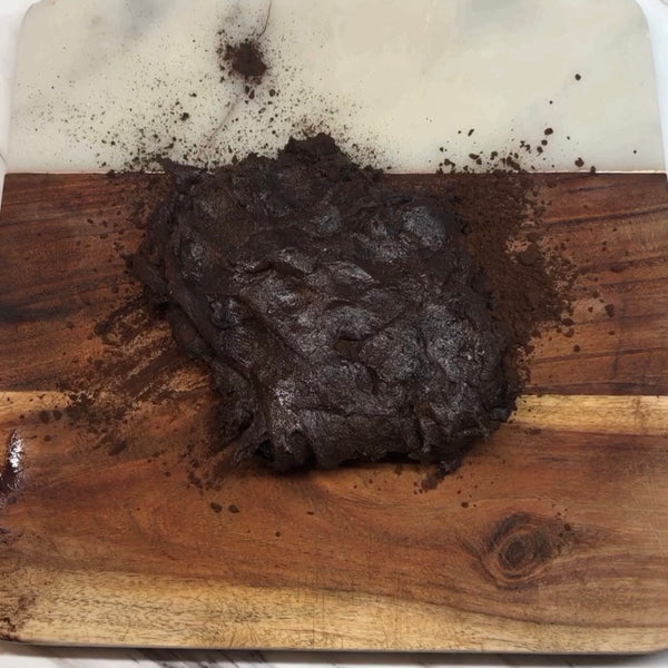 adding the cooled chocolate mochi to the cutting board dusted with cocoa powder