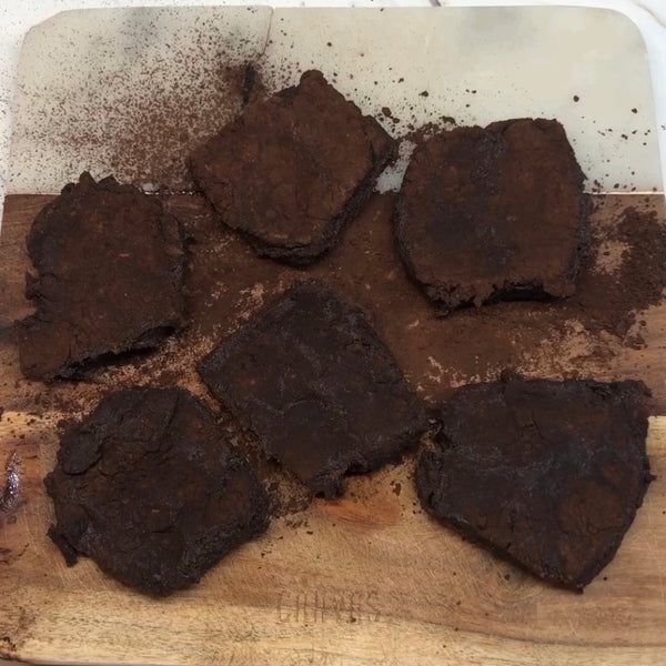 dusting each piece of chocolate mochi in cocoa powder