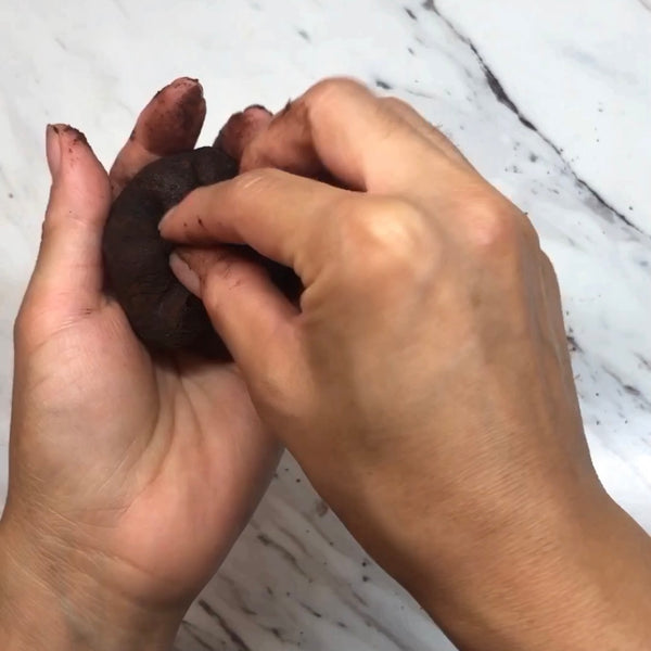 forming the chocolate mochi into a ball and pinching the seams at the bottom together