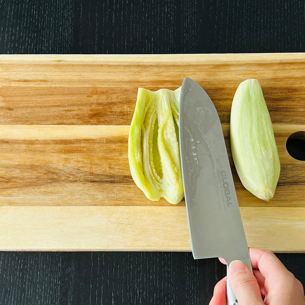 flattening the eggplant with the back of a knife