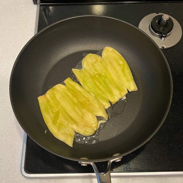 placing the eggplants in a frying pan