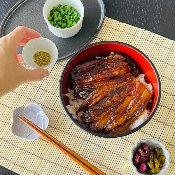 plating the eggplant unagi and topping it with sansho powder