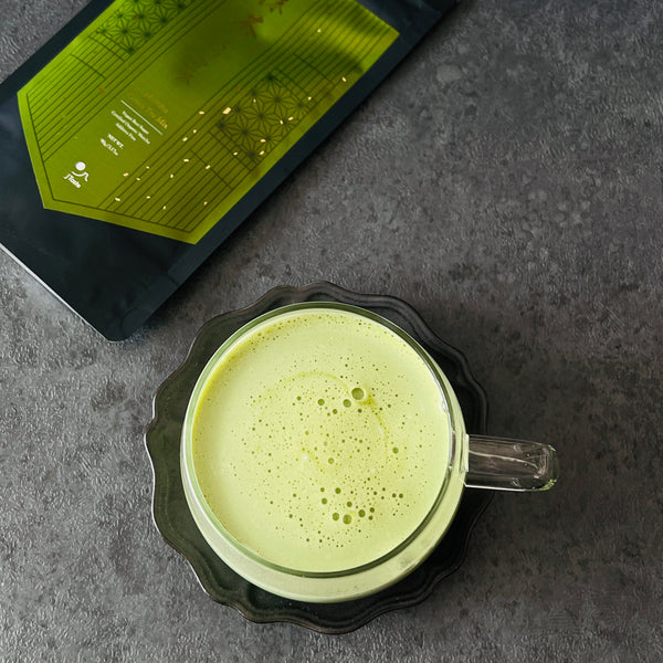 adding hot milk to make a matcha latte