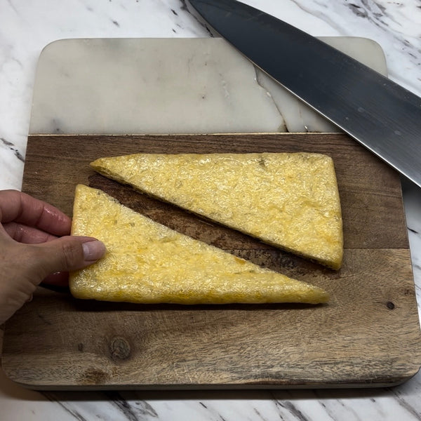 cutting the flattened tofu pouch in half