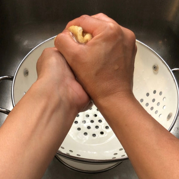 wringing out the excess water from the tofu pouches