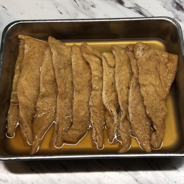 placing the seasoned tofu pouches on a tray