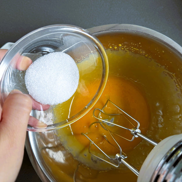 adding granulated sugar to the egg yolks