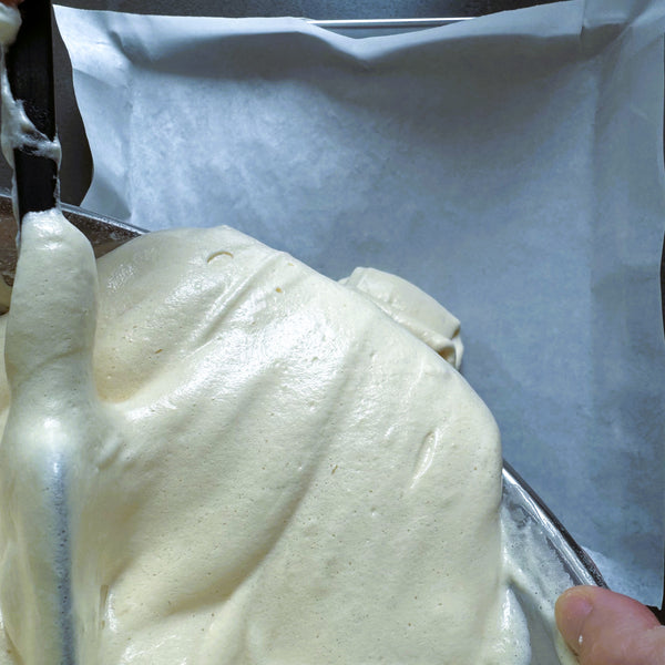 pouring the cake batter onto the sheet pan