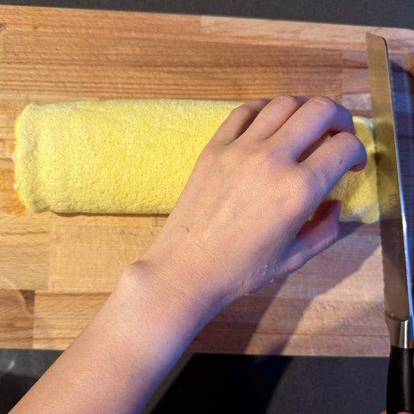 using a serrated knife to cut the cake into slices