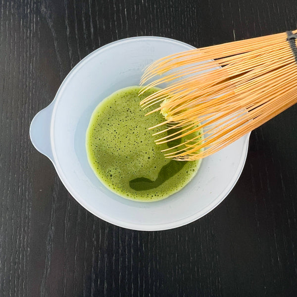 whisking matcha with a chasen bamboo whisk