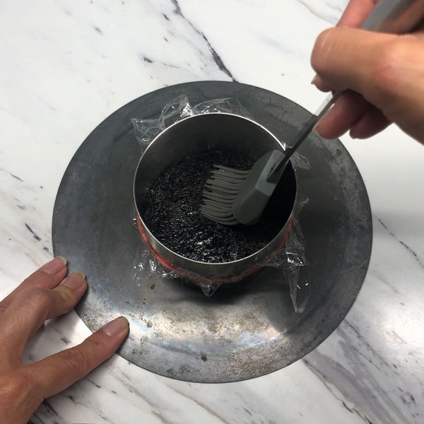 brushing the top of the cake with sugar syrup