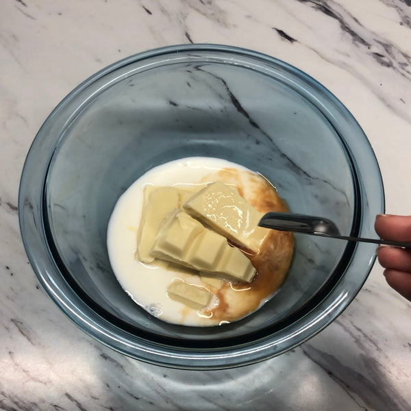 adding white chocolate, vanilla, and milk into another bowl