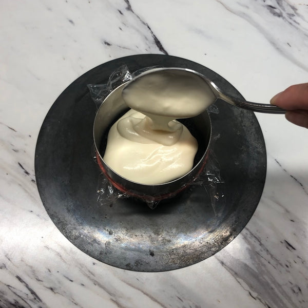 adding the white chocolate mousse on top of the chocolate cake