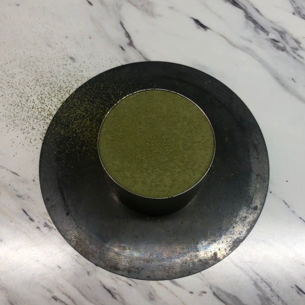 dusting the matcha mousse cake with matcha powder