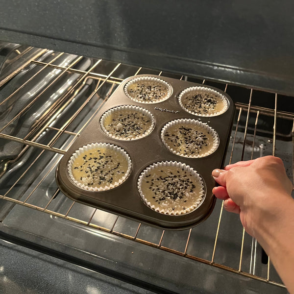 placing the mochi muffins into a preheated oven