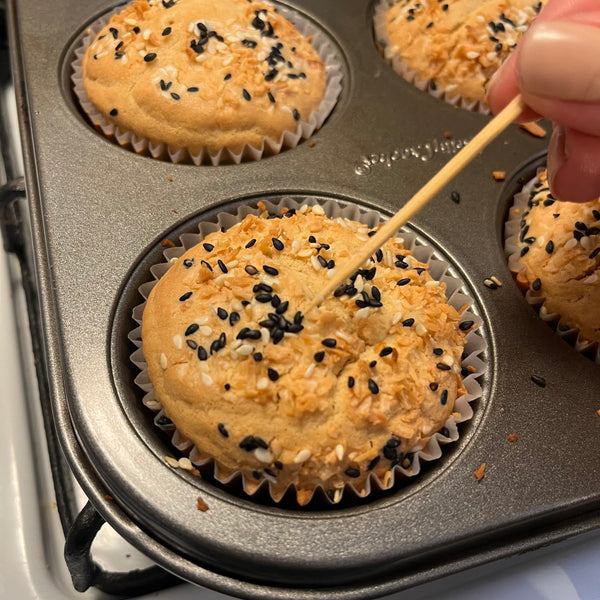 checking the doneness of the mochi muffins with a toothpick