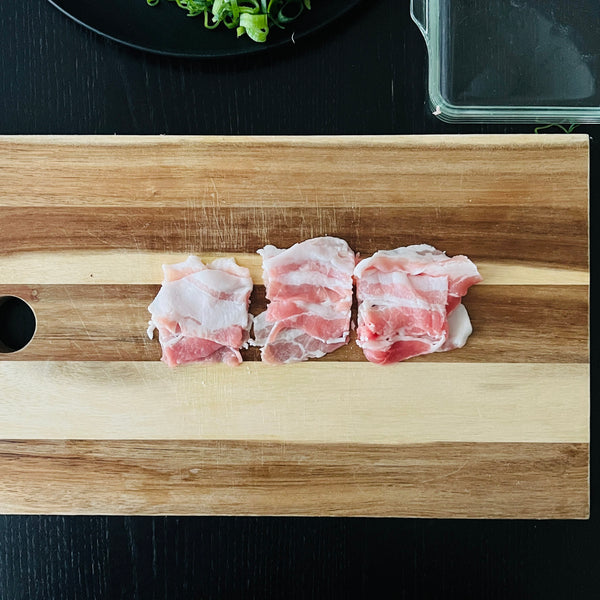 cutting the pork belly into bite sized pieces