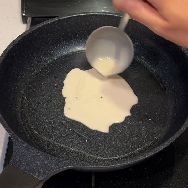 pouring the negiyaki batter into the pan