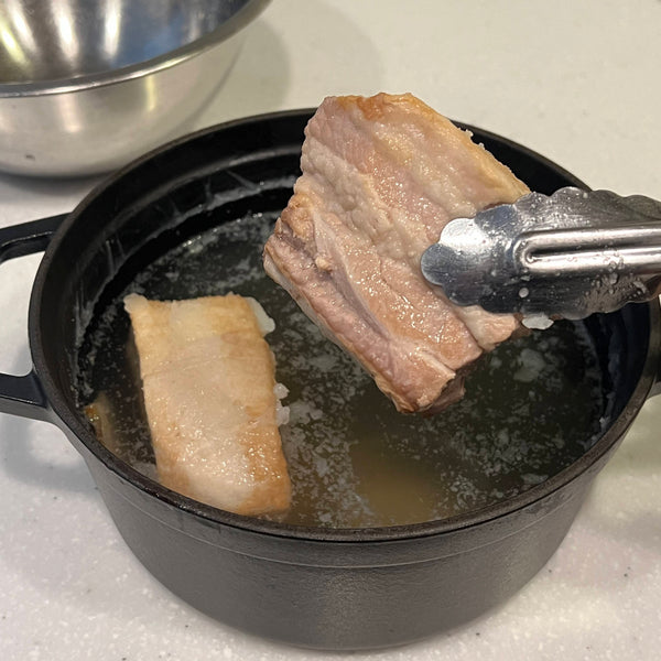 removing the pieces of pork from the broth