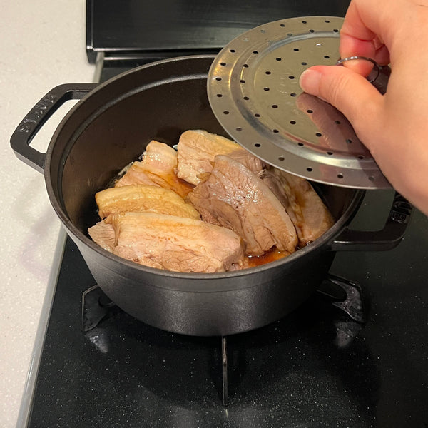 adding a drop lid over the pork belly slices