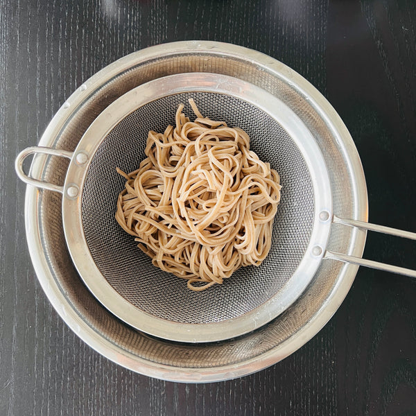 draining the cooled soba noodles