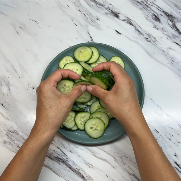 rubbing the salt into the cucumbers