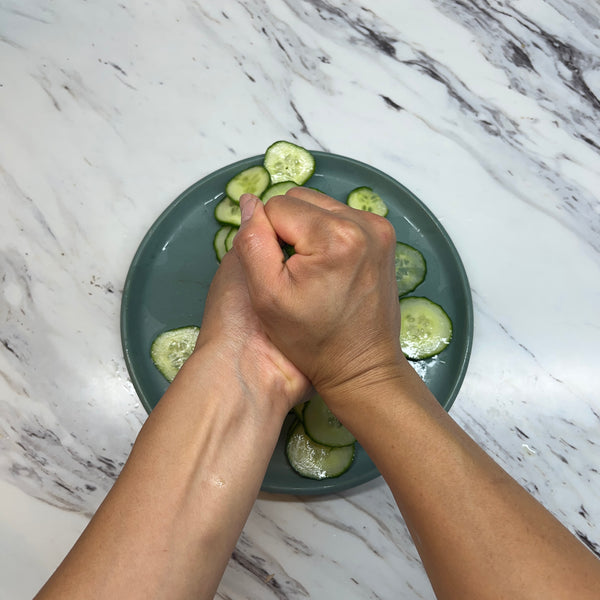 squeezing excess water out of the cucumbers