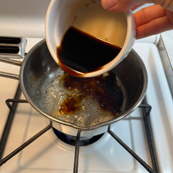 pouring soy sauce into the pot