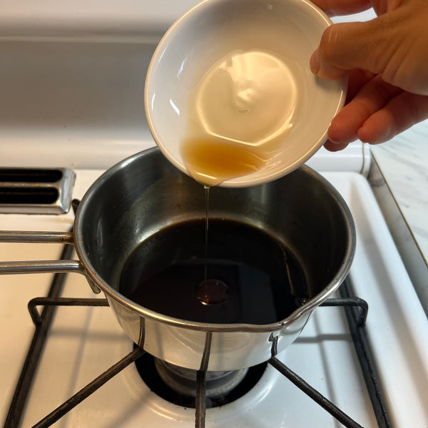 pouring sesame oil into the dressing