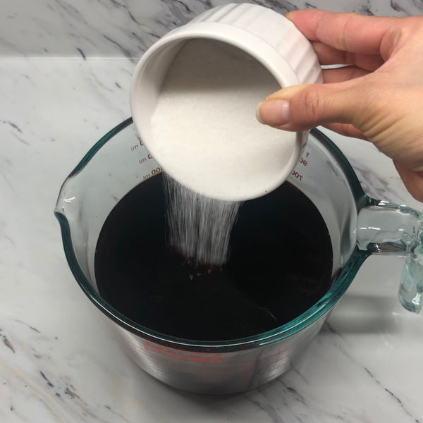 pouring sugar into the coffee