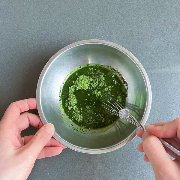 stirring the matcha powder with hot water