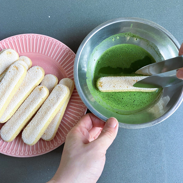 dipping ladyfinger into the matcha