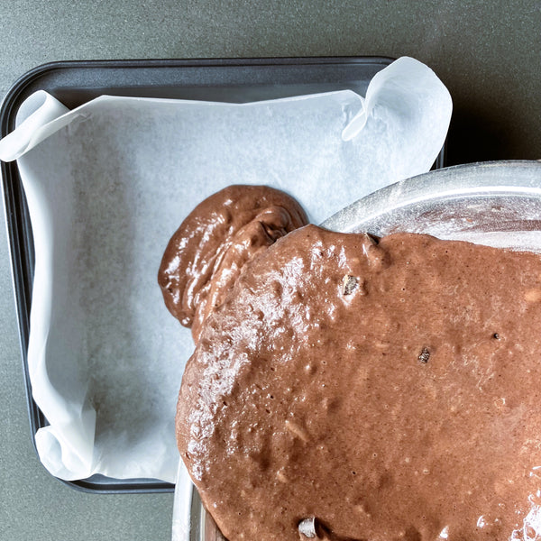 pouring the brownie batter into the pan