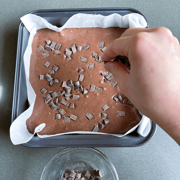 putting the rest of the chocolate chunks onto the brownies