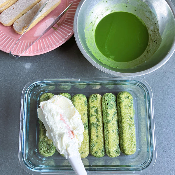 adding a layer of cream on top of the matcha ladyfingers