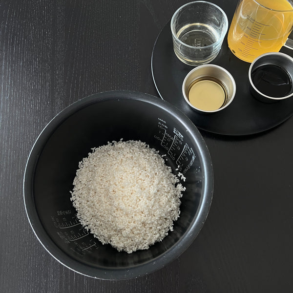 adding rice to the rice cooker bowl