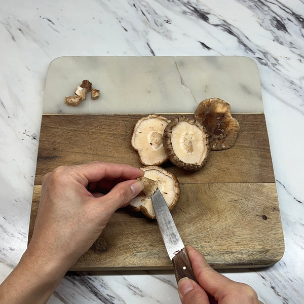 removing the stems from shiitake mushrooms