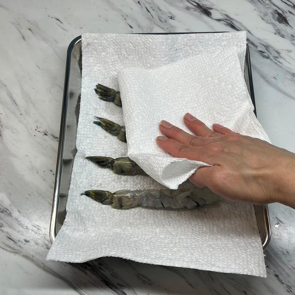 patting the shrimps dry with paper towels