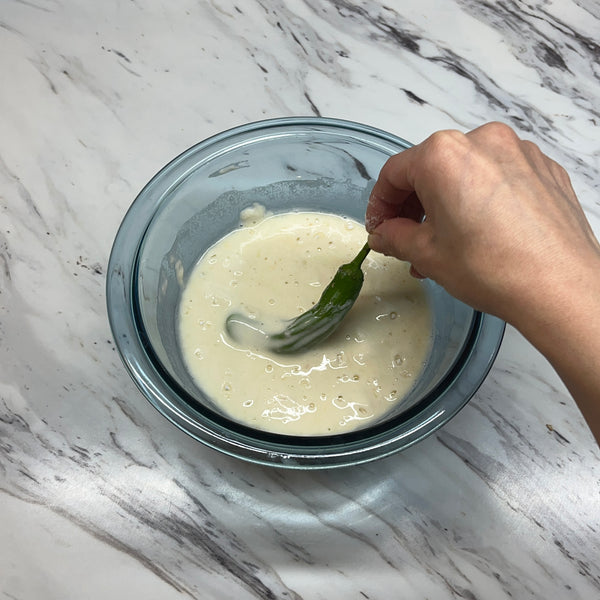 dipping the tempura ingredients into the tempura batter